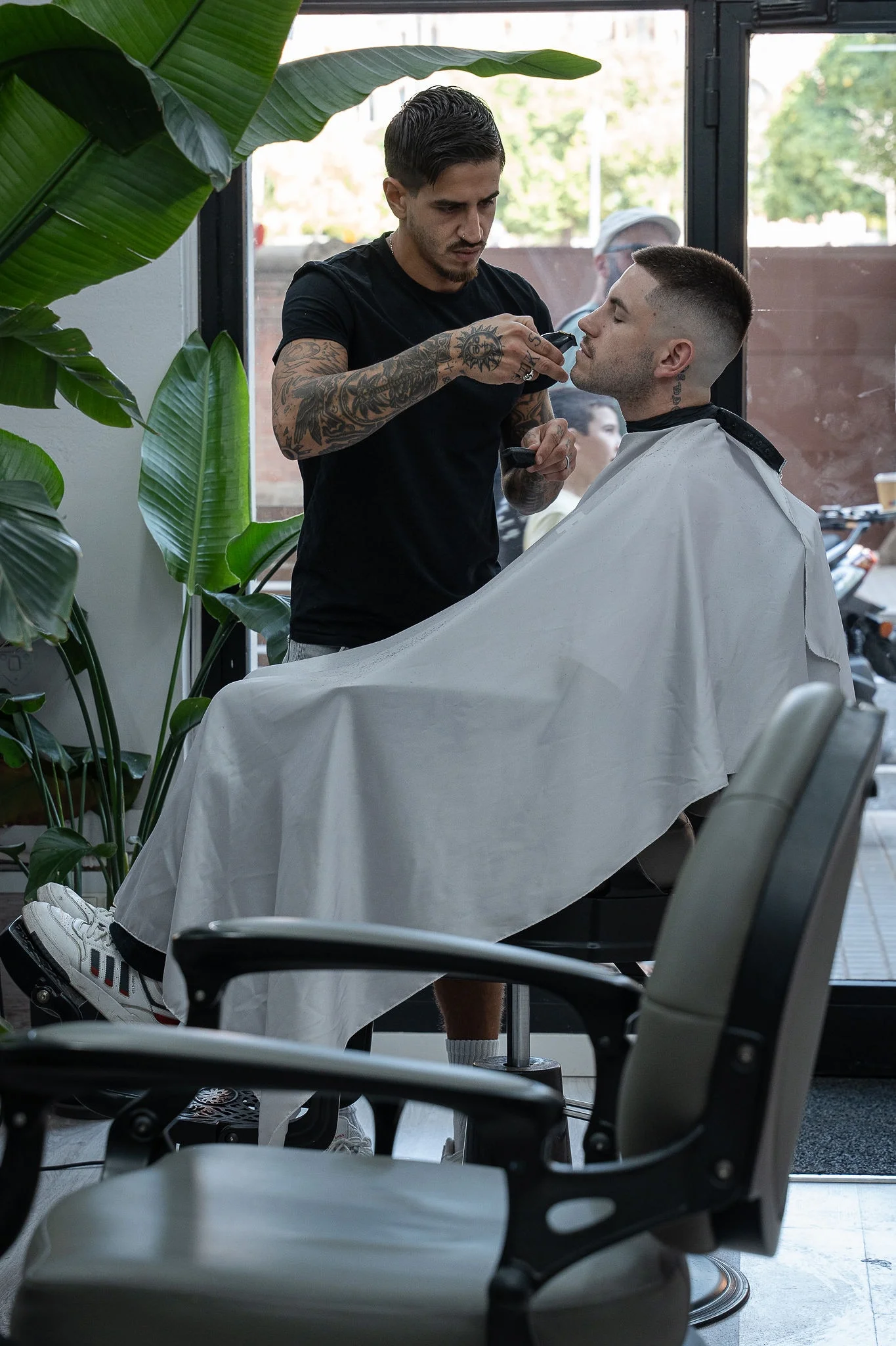 Barbero atendiendo a contraluz junto al ventanal