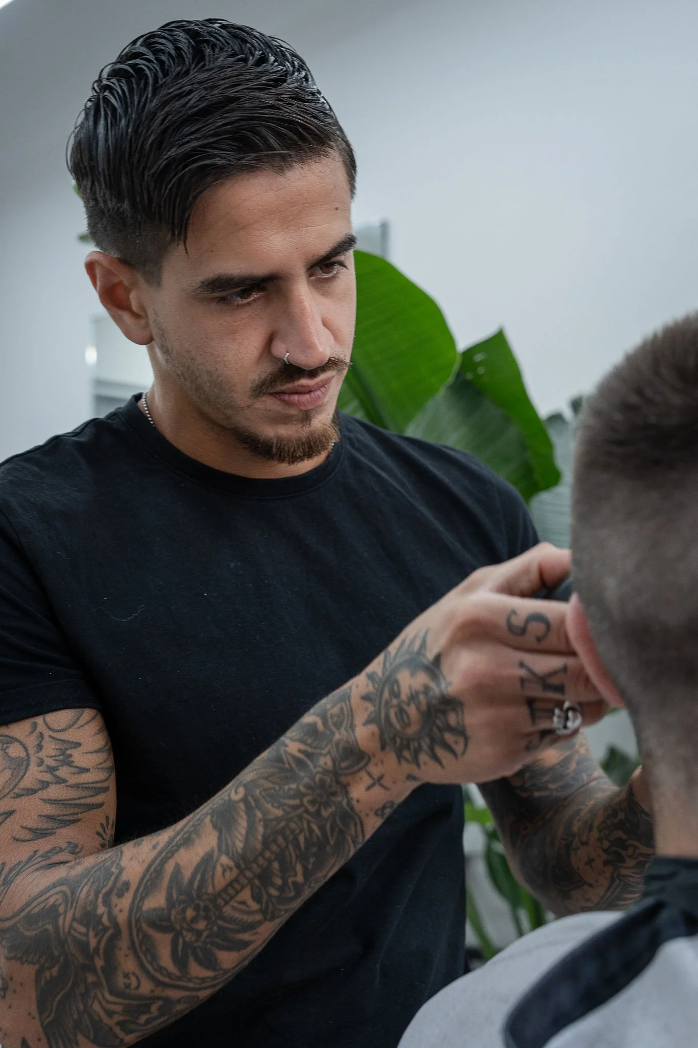 Martin rematando un corte, con las plantas del local al fondo