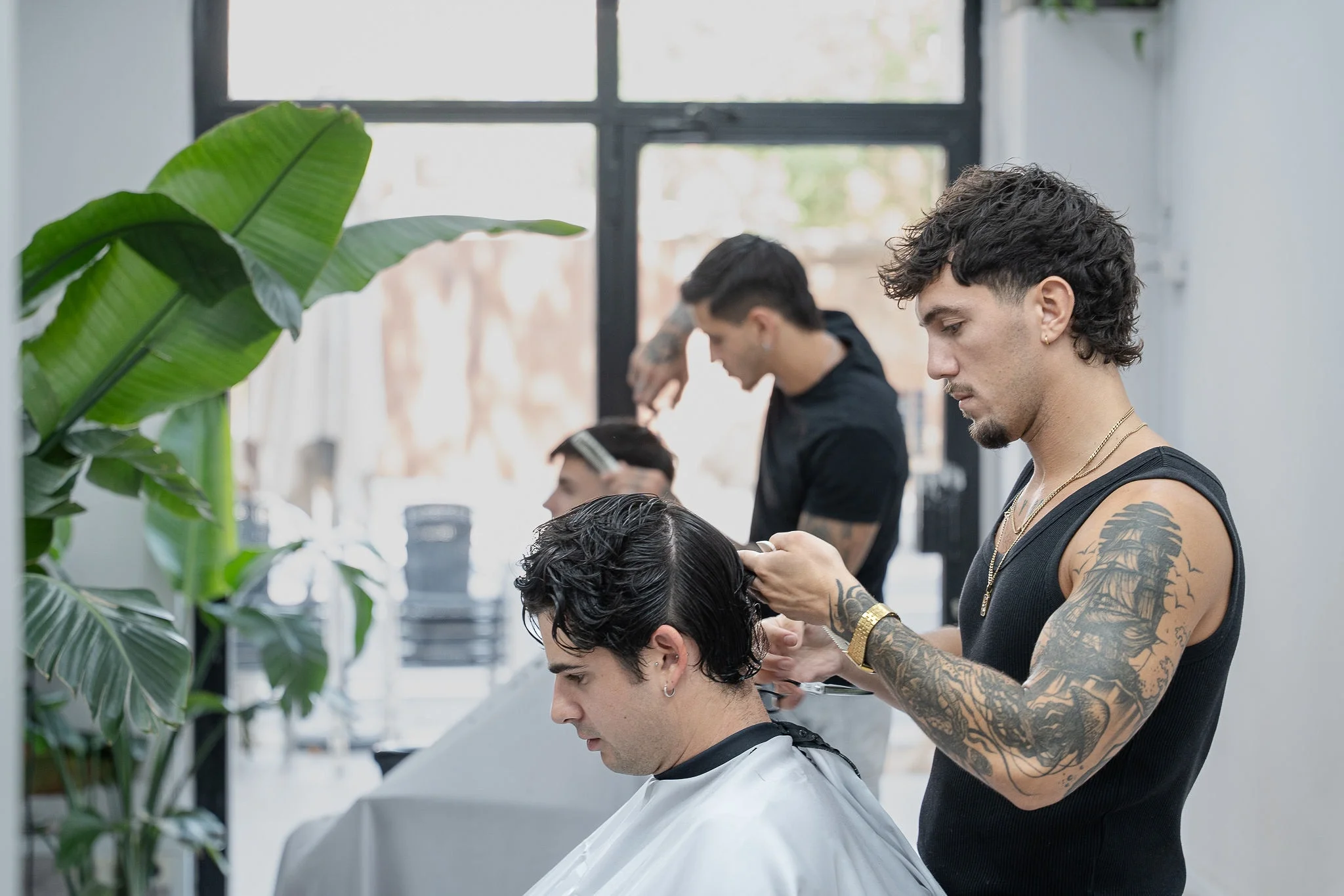 Interior de Stockers Barbershop con un barbero atendiendo junto al ventanal